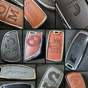 May include: A collection of personalized keychains with various designs and names, including "Susan", "Katelyn", "Jonathan", "MW", "Jasmin", "Stormy", "USN", "BMW", "ORSZ", and "US Marine Corps".