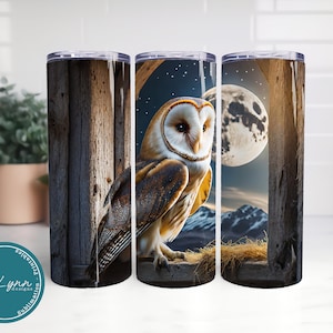 May include: A set of three stainless steel tumblers with a design of a barn owl perched on a windowsill with a full moon and stars in the background. The owl is brown and white with yellow eyes. The windowsill is made of weathered wood.
