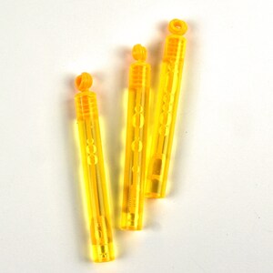 May include: Three yellow plastic bubble wands with a clear liquid inside. The wands have a small loop at the top for holding.