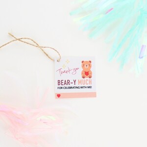 May include: A thank you tag with a brown bear holding a red heart. The tag says "Thank you BEAR-Y MUCH for celebrating with me!" with a small red heart at the bottom.