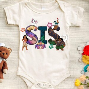May include: White baby onesie featuring a colourful graphic of the word "SIS" with characters from the film Moana. The letters are decorated with flowers and other tropical elements.