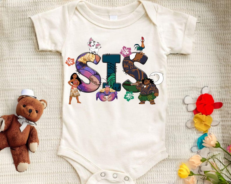 May include: White baby onesie featuring a colourful graphic of the word "SIS" with characters from the film Moana. The letters are decorated with flowers and other tropical elements.