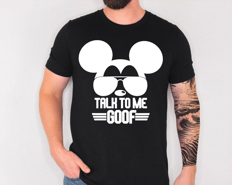 May include: A black short-sleeved t-shirt featuring a large white graphic of a mouse silhouette wearing aviator sunglasses. Below the graphic, the text reads TALK TO ME GOOF in bold white capital letters, flanked by two horizontal white lines.