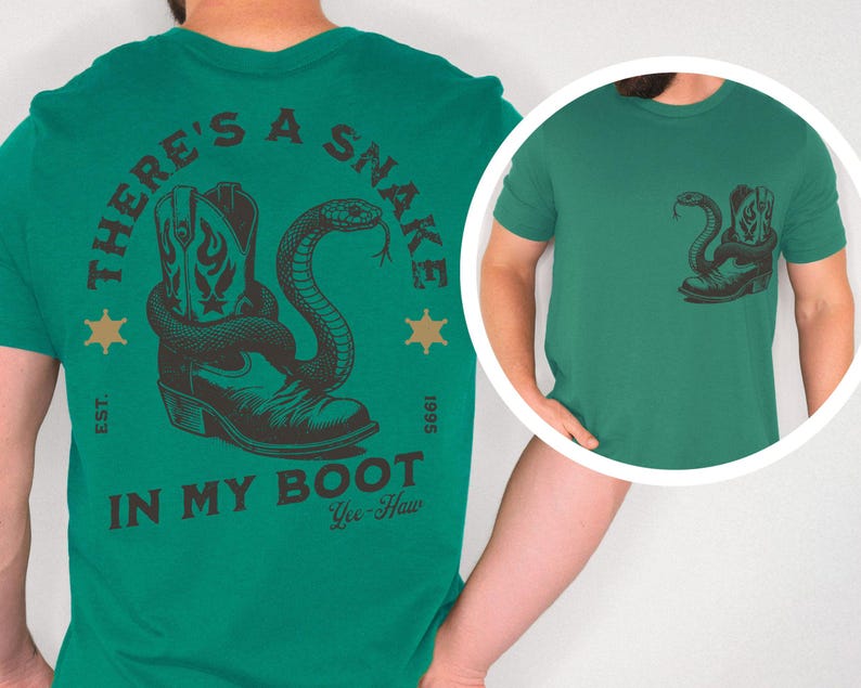 Puede incluir: Camiseta verde con un dise&ntilde;o de una bota de vaquero y una serpiente. El texto "THERE'S A SNAKE IN MY BOOT" est&aacute; impreso encima y debajo del dise&ntilde;o. La camiseta tambi&eacute;n tiene el texto "Yee-Haw" y "EST. 1995".