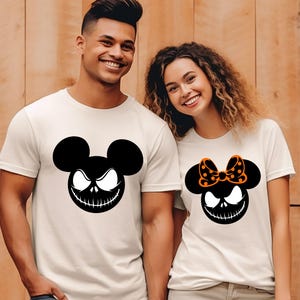 Puede incluir: Camisetas blanquecinas con un gr&aacute;fico en blanco y negro de un personaje parecido a un rat&oacute;n con una sonrisa siniestra. Una camiseta tiene un lazo con lunares naranjas. Ropa tem&aacute;tica de Halloween.