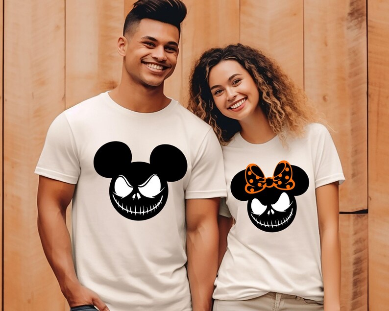 Puede incluir: Camisetas blanquecinas con un gr&aacute;fico en blanco y negro de un personaje parecido a un rat&oacute;n con una sonrisa siniestra. Una camiseta tiene un lazo con lunares naranjas. Ropa tem&aacute;tica de Halloween.
