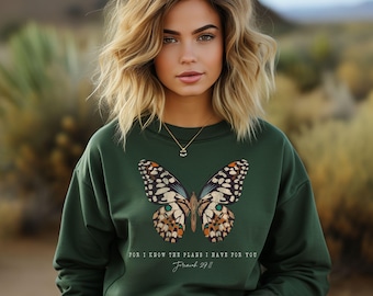 May include: A dark green sweatshirt with a colorful butterfly graphic and the text "For I know the plans I have for you, Jeremiah 29:11".
