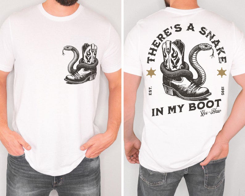 Puede incluir: Camiseta blanca con un dise&ntilde;o en blanco y negro de una bota de vaquero y una serpiente. La parte delantera de la camiseta muestra la bota y la serpiente, y la parte trasera tiene el texto "THERE'S A SNAKE IN MY BOOT".