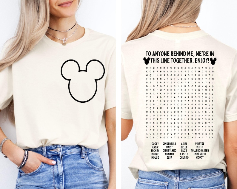 K&ouml;nnte beinhalten: Cremefarbenes T-Shirt mit einer gro&szlig;en schwarzen Mickey Mouse-Umrisslinie auf der Vorderseite. Auf der R&uuml;ckseite des Shirts steht der Text "TO ANYONE BEHIND ME, WE'RE IN THIS LINE TOGETHER. ENJOY!" und ein Disney-Wortsuchr&auml;tsel.