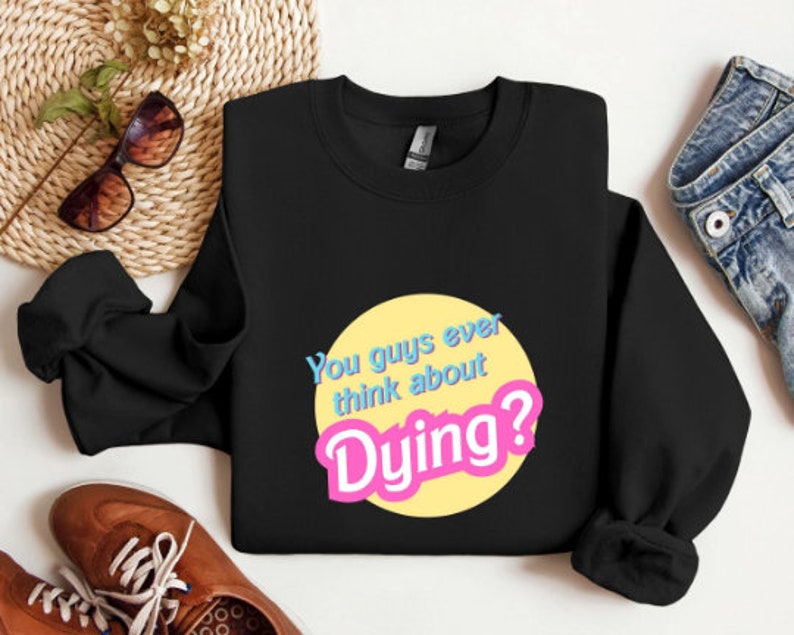 May include: Black sweatshirt with a yellow circle and the text "You guys ever think about Dying?" in pink and blue letters.
