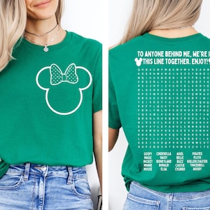 K&ouml;nnte beinhalten: Gr&uuml;nes T-Shirt mit wei&szlig;em Minnie Mouse-Design auf der Vorderseite. Auf der R&uuml;ckseite des Shirts steht der Text "TO ANYONE BEHIND ME, WE'RE IN THIS LINE TOGETHER. ENJOY!" und ein Wortsuchr&auml;tsel mit Disney-Figuren.
