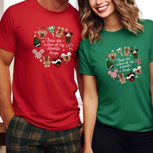 May include: Red and green t-shirts with a Christmas-themed design featuring Mickey Mouse and gingerbread characters. The text on the shirts reads "These are a few of my favorite things."