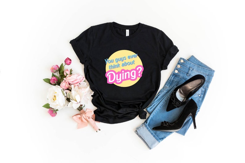 May include: Black t-shirt with a yellow circle and the text "You guys ever think about Dying?" in pink and blue letters.