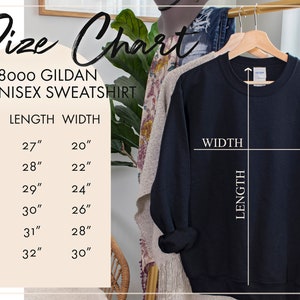May include: Size chart for a unisex sweatshirt. The chart shows the length and width in inches for sizes S, M, L, XL, 2X, and 3X. A black sweatshirt is hanging on a hanger.