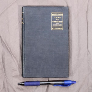 May include: A black hardcover book with gold lettering on the spine. The title is "Vicar of Wakefield" by Goldsmith. The book is part of the Academy Classics series published by Allyn and Bacon.