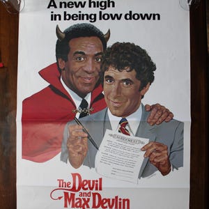 May include: A vintage movie poster for "The Devil and Max Devlin" features two men. One is dressed as the devil in a red cape and horns. The other man is in a suit, holding a pen and a document. The poster's title is in red.
