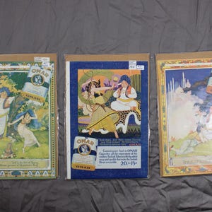 May include: Three vintage advertisements for Omar Turkish Cigarettes. The first ad features a woman in a white dress and a man in a blue robe in a garden setting. The second ad features a woman in a blue dress and a man in a red robe sitting on a rug. The third ad features a woman in a white dress and a man in a blue robe in a desert setting. All three ads feature the Omar brand logo and the text "Omar Turkish Cigarettes".