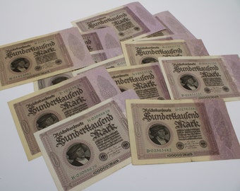 May include: A collection of vintage German banknotes, each featuring a portrait of a man and the text "Reichsbanknote Hunderttausend Mark".