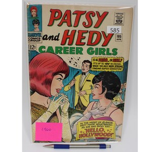May include: A vintage comic book cover featuring Patsy and Hedy Career Girls. The cover is red, white, and blue with a yellow background. The title is "Patsy and Hedy Career Girls" and the issue number is 105. The cover features two women, Patsy and Hedy, and a man. The text on the cover reads "Is he hero... or heel? It's up to you to decide when you meet Rick Strong singing super-sensation!"