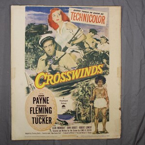 May include: Vintage movie poster for "Crosswinds" in Technicolor. The poster features John Payne, Rhonda Fleming, and Forrest Tucker. The artwork depicts a jungle scene with characters and the film's title.