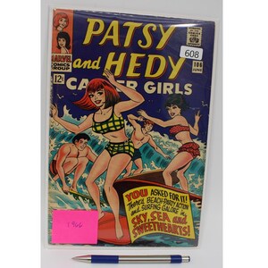May include: A vintage comic book cover featuring Patsy and Hedy, two girls in swimsuits, surfing on a wave. The cover is in bright colors with a blue background and the title "Patsy and Hedy Surfer Girls" in large, bold letters. The comic book is from June 1966 and is issue number 106.