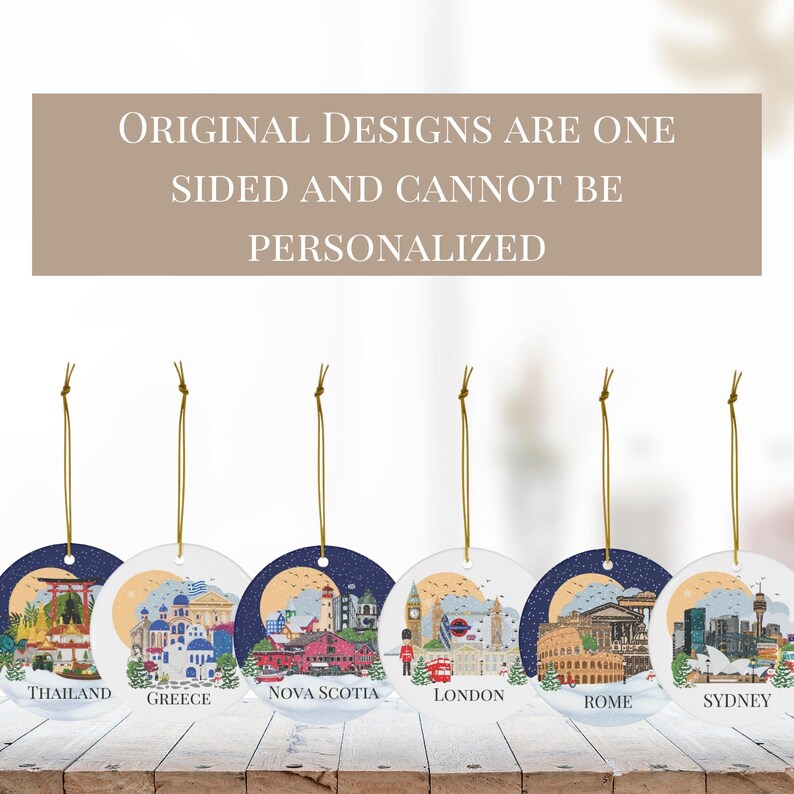 May include: Six round hanging ornaments featuring illustrations of Thailand, Greece, Nova Scotia, London, Rome, and Sydney. Each ornament has a gold string and text stating: ORIGINAL DESIGNS ARE ONE SIDED AND CANNOT BE PERSONALIZED.