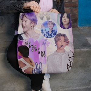 May include: A tote bag with a collage of images of a young man with purple hair. The images are in a variety of poses and expressions, and are surrounded by colorful abstract shapes and designs. The text "Jimin" is written in a stylized font on the bag.