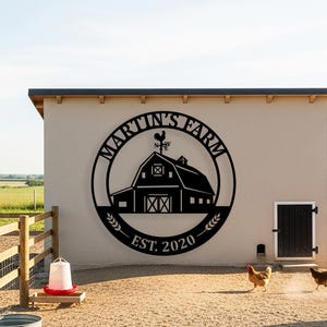 May include: Black metal barn sign with the text "MARTIN'S FARM" in a circular design, featuring a barn silhouette and wheat stalks. The sign includes "EST. 2020" and a weather vane. Chickens are walking in the foreground.