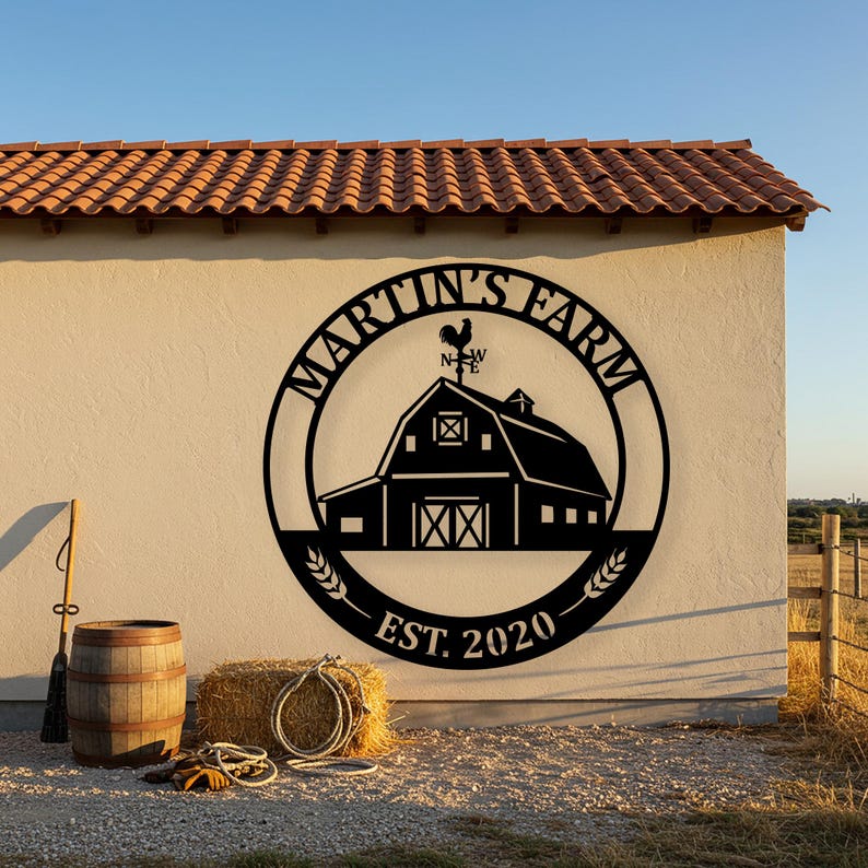 May include: Black metal farm sign with the text "Martin's Farm" in a circular design, featuring a barn silhouette and a rooster weathervane. The sign includes "EST. 2020" and wheat stalks. A barrel, hay bale, and rope are in the foreground.