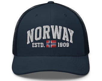 May include: A navy blue trucker hat with a white mesh back. The front of the hat features white embroidered text that reads "NORWAY ESTD. 1909" with a small embroidered Norwegian flag.