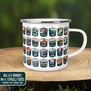May include: White enamel camping mug with a silver rim and handle. The mug features a design of all 63 US National Parks, each with a unique illustration and name. The text "ALL 63 PARKS! IN 4 STYLES/SIZES CAMPING MUG SHOWN HERE" is printed below the design.