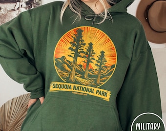 May include: A dark green hooded sweatshirt featuring a vintage-style graphic of three sequoia trees in a circle with the text "Sequoia National Park Established 1890".