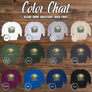 May include: Colour chart displaying various colour options for a Gildan 18000 sweatshirt featuring a print of the Rocky Mountain National Park logo. The colours include white, grey, sand, military green, forest green, dark heather, charcoal, maroon, royal blue, navy blue, and black.