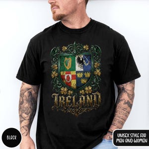 May include: Black t-shirt featuring a detailed crest design with the word "Ireland" in gold lettering. The crest includes a harp, eagle, and crowns, surrounded by shamrocks. The shirt is labeled "Unisex Style for Men and Women".