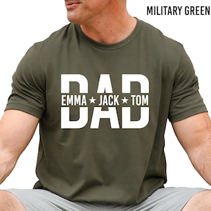 A man wearing a green t-shirt with the text "DAD" printed on it, along with the names "Emma Jack Tom".