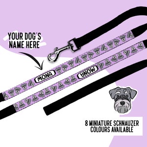 Könnte beinhalten: Eine schwarze Hundeleine mit einem lavendelfarbenen Band, das ein wiederkehrendes Muster aus grauen Zwergschnauzer-Köpfen und dem Namen MONA in einem weißen Oval zeigt. Die Leine hat einen silbernen Metallkarabiner und eine Schnauzer-Grafik.