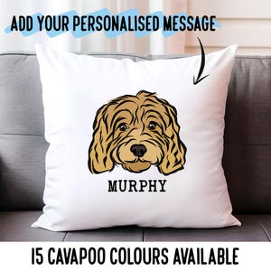 Op de afbeelding: Een wit kussen met een bruine en witte illustratie van een cavapoo-hond met de naam "Murphy" eronder gedrukt. De tekst "15 CAVAPOO COLORS AVAILABLE" staat onderaan de afbeelding.