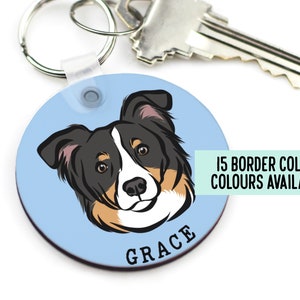 Può includere: Portachiavi rotondo blu con un'illustrazione di border collie nero, bianco e marrone. Il testo "GRACE" è stampato sotto il viso del cane. Il testo "15 BORDER COLLIE COLOURS AVAILABLE" è stampato in verde su sfondo bianco.