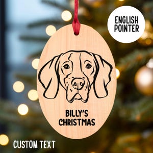 May include: A wooden Christmas ornament featuring a black and white illustration of an English Pointer dog's head. The ornament is oval shaped and has the text "Billy's Christmas" printed on it.