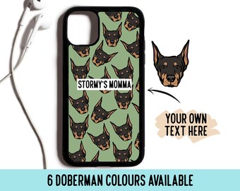 Può includere: Una custodia per telefono nera con sfondo verde e un motivo ripetuto di teste di cani Doberman Pinscher. Il testo "STORMY'S MOMMA" è stampato sulla custodia. Un'immagine separata mostra una testa di Doberman Pinscher con il testo "YOUR OWN TEXT HERE".