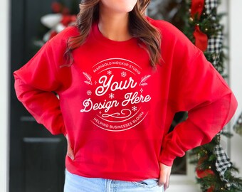 May include: Red sweatshirt with a white circle design that says "Marigold Mockup Studio" and "Your Design Here" with snowflakes and leaves. The text below the circle says "Helping Businesses Bloom".