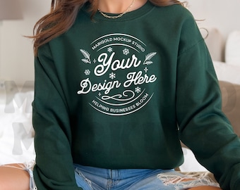 May include: A dark green sweatshirt with a white circle design that says "Marigold Mockup Studio" and "Your Design Here" with snowflakes and leaves. The text below the circle says "Helping Businesses Bloom".