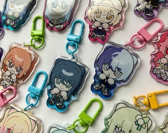 May include: A collection of colorful character keychains with different designs. Each keychain features a cartoon character with a unique expression and pose. The keychains are made of clear acrylic and have a metal ring for attaching to keys or bags.