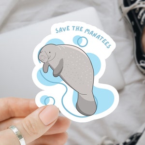May include: A sticker with a cartoon manatee swimming in blue water. The sticker says "Save the Manatees".