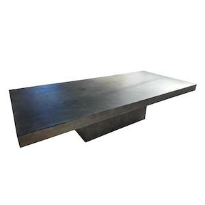 May include: A long, rectangular, dark grey coffee table with a single, rectangular, dark grey base.