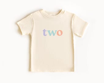 May include: A cream colored short-sleeved t-shirt with the word "two" printed on the front in pastel blue, purple, and orange letters.