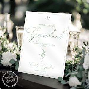 Könnte beinhalten: Ein weißes Hochzeits-Gästebuch-Schild mit grünem Blumendesign und dem Text "EJ Bitte unterschreiben Sie unser Gästebuch Vielen Dank, dass Sie diesen besonderen Tag mit uns teilen. Emily - Joshua 25. September 2025"