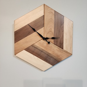 May include: A hexagonal wooden clock with black hands and a geometric pattern of light and dark wood.