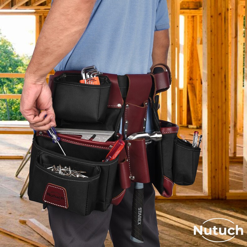 May include: A black and burgundy tool belt with multiple pockets and tool holders. The belt is filled with various tools, including a hammer, screwdrivers, and wrenches. The brand name "Nutuch" is visible on the front pocket.