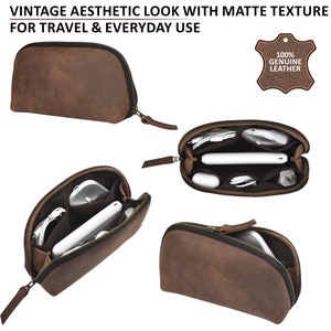 Puede incluir: Una bolsa de cuero marr&oacute;n con cremallera de est&eacute;tica vintage. La bolsa est&aacute; abierta y muestra varios compartimentos para guardar objetos peque&ntilde;os como cables, cargadores y un tel&eacute;fono. La bolsa est&aacute; hecha de cuero genuino 100%.